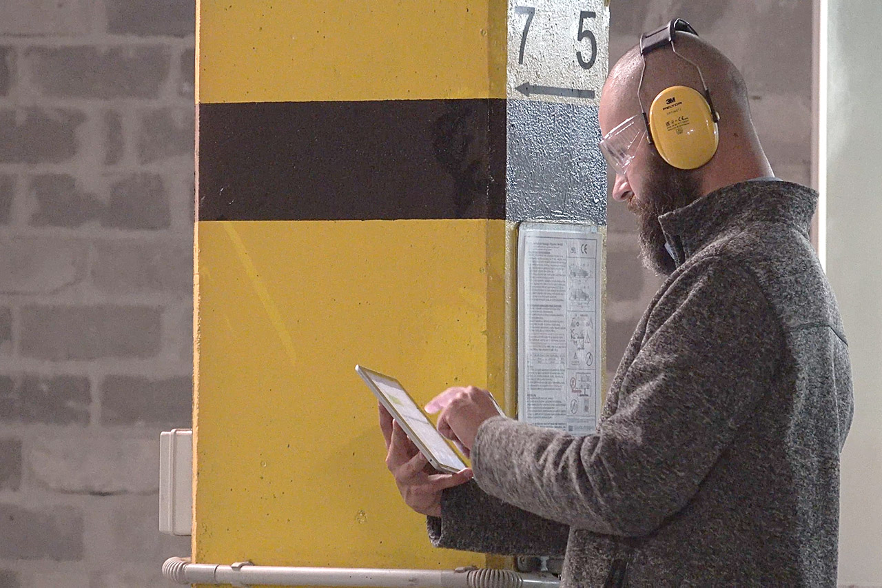 Production worker using a tablet in an industrial facility