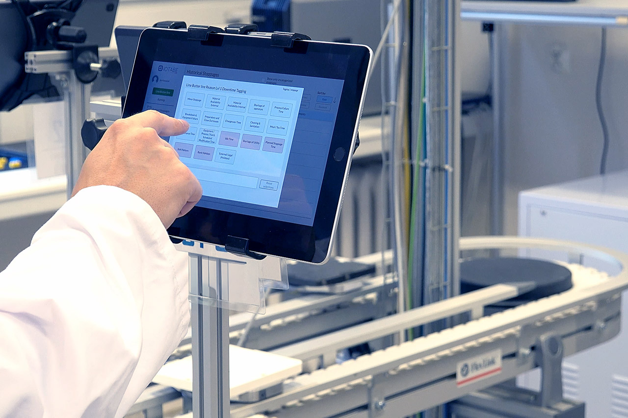 Operator using the CORE OEE interface on a tablet at a production line